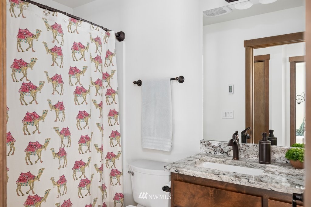 1471 North View Road Oak Harbor, WA 98277 - Photo 28 of 38 a bathroom with a granite countertop sink a mirror and shower curtain