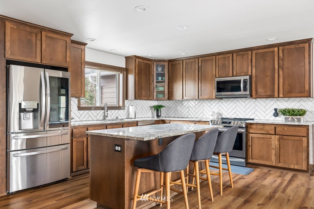 1471 North View Road Oak Harbor, WA 98277 - Photo 7 of 38 a kitchen with stainless steel appliances wooden cabinets granite counter tops and a stove