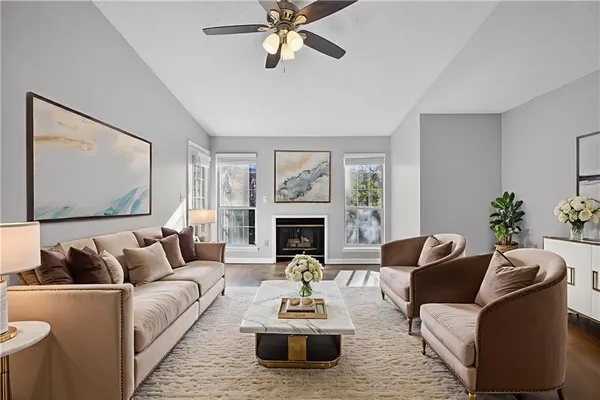 a living room with furniture a fireplace and a large window