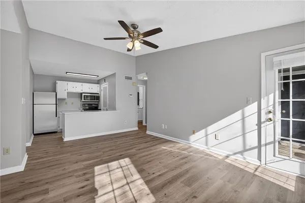a view of a livingroom with wooden floor and a ceiling fan