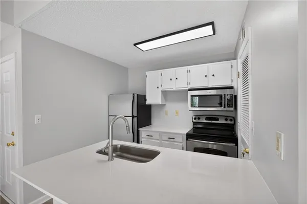 a kitchen with stainless steel appliances a stove a sink and a refrigerator