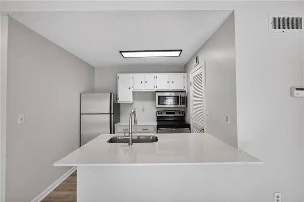 a kitchen with stainless steel appliances a sink and a refrigerator