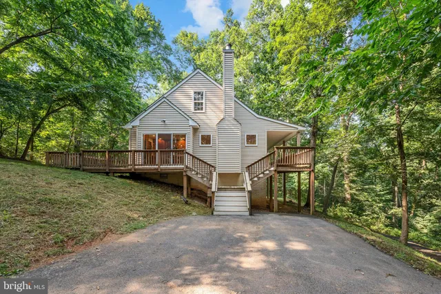 a view of a house with a yard and large tree