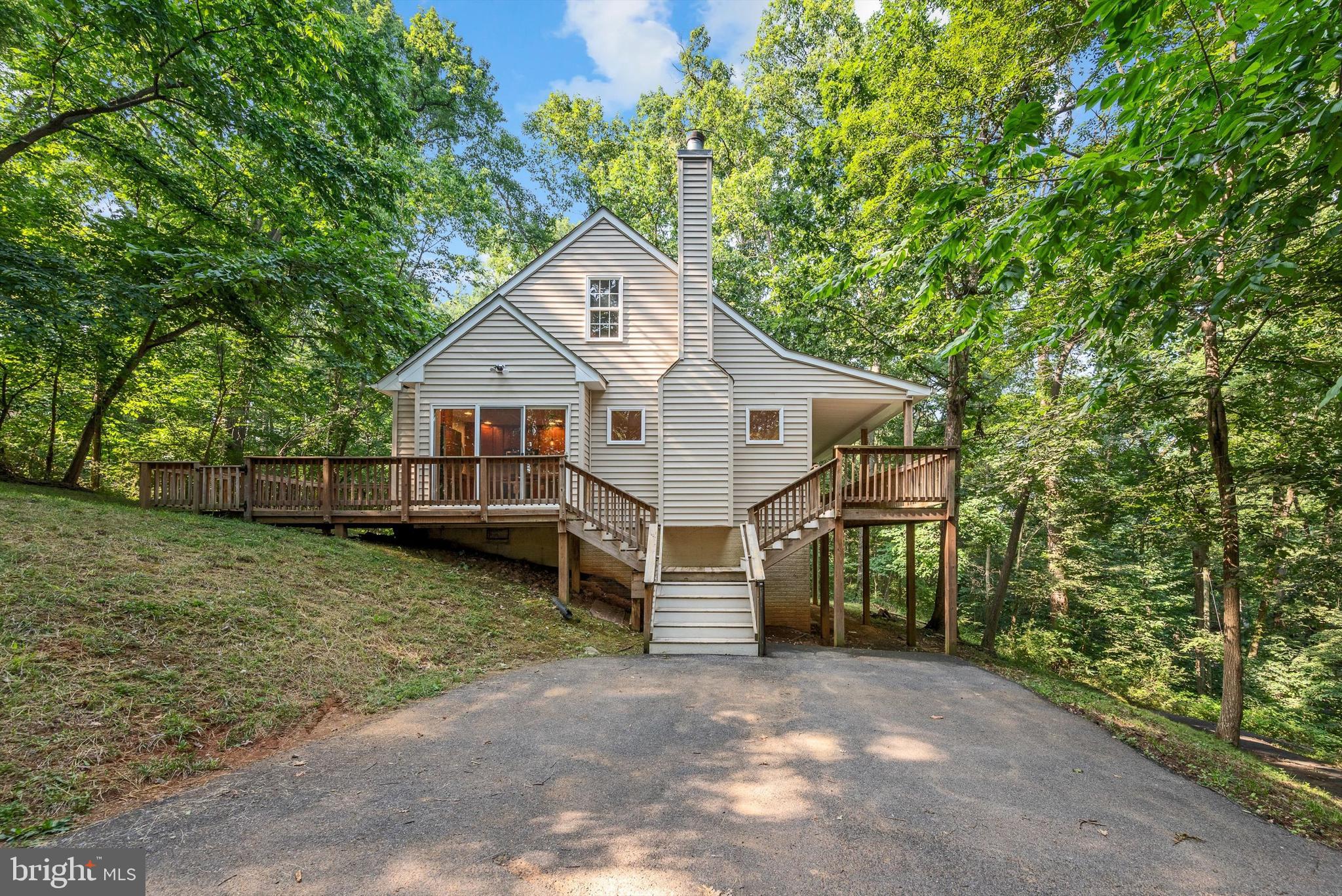 a view of a house with a yard and large tree
