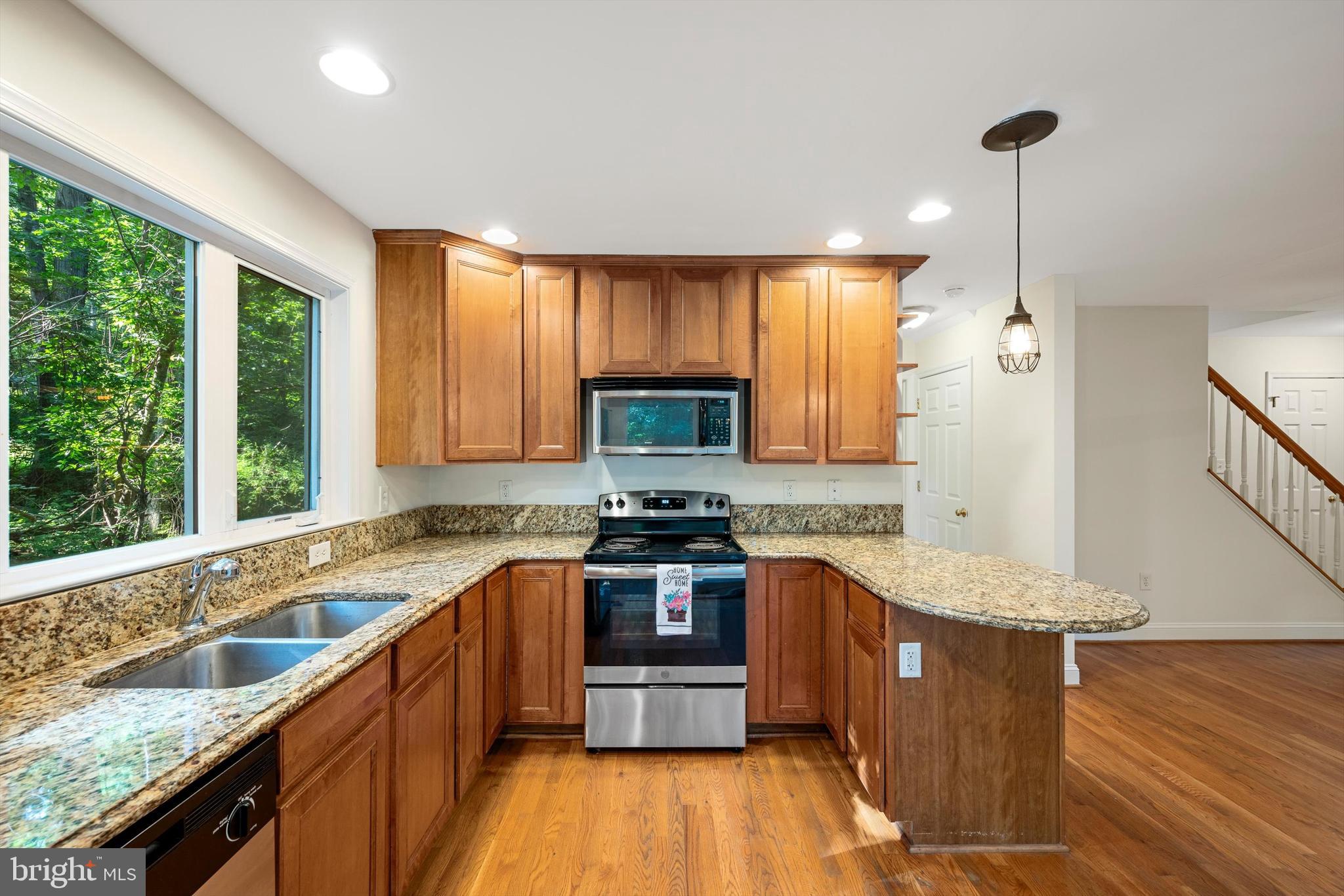 175 Easy Hollow Road Front Royal, VA 22630 - Photo 13 of 42 a kitchen with stainless steel appliances granite countertop wooden cabinets a stove top oven a sink and dishwasher with wooden floor