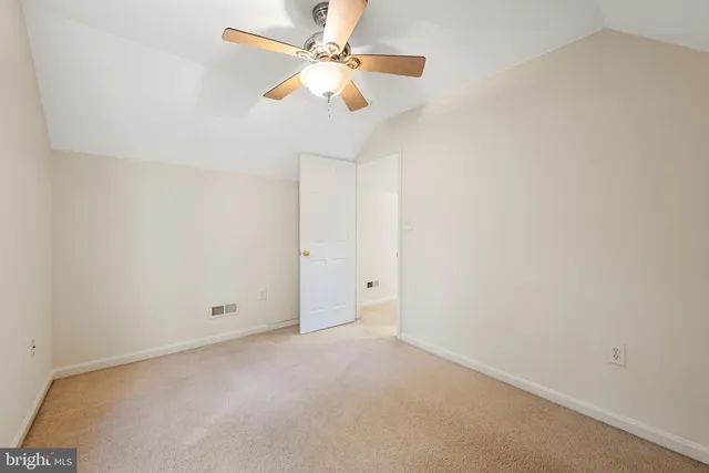 an empty room with a chandelier fan and a ceiling fan