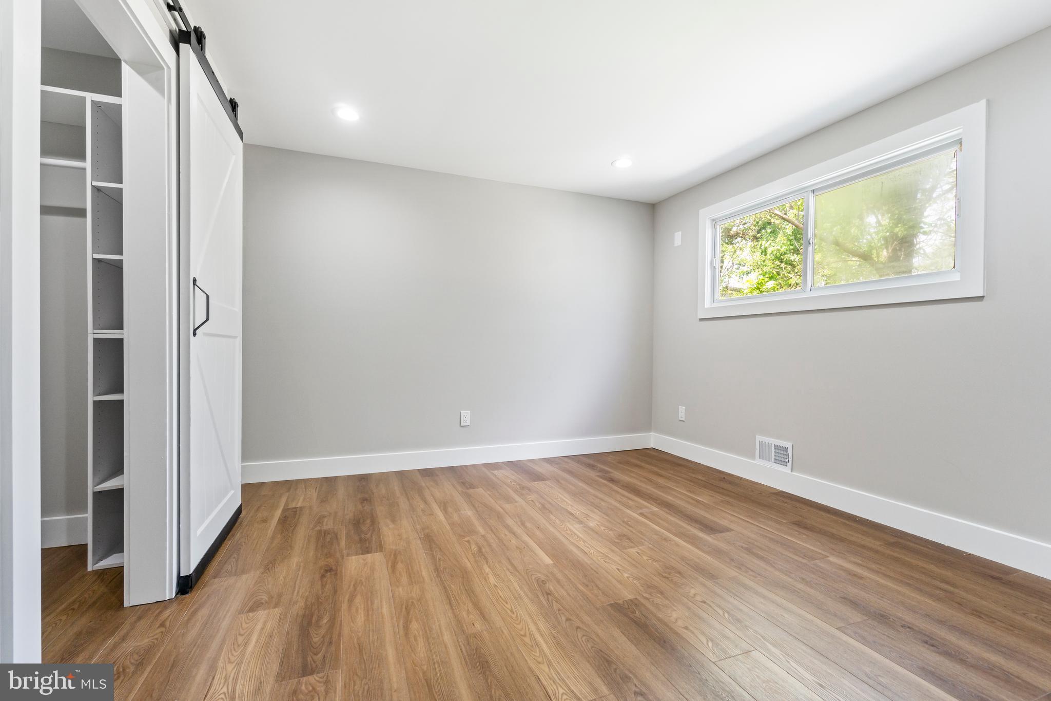 4534 Old Court Road Baltimore, MD 21208 - Photo 13 of 26 a view of an empty room with wooden floor and a window