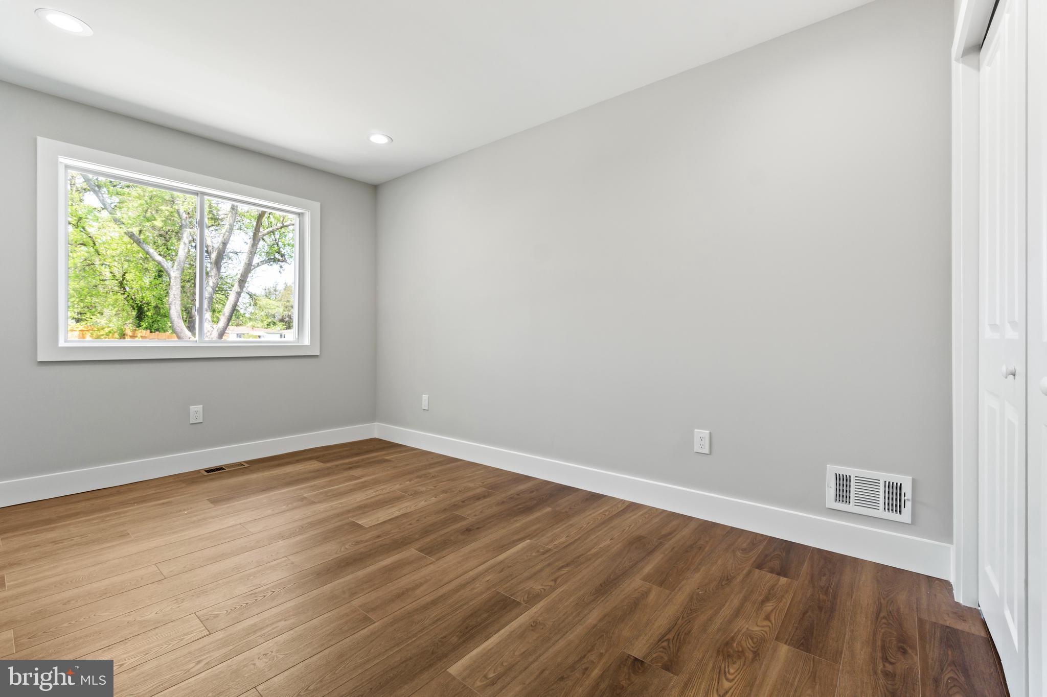 4534 Old Court Road Baltimore, MD 21208 - Photo 14 of 26 an empty room with wooden floor and windows