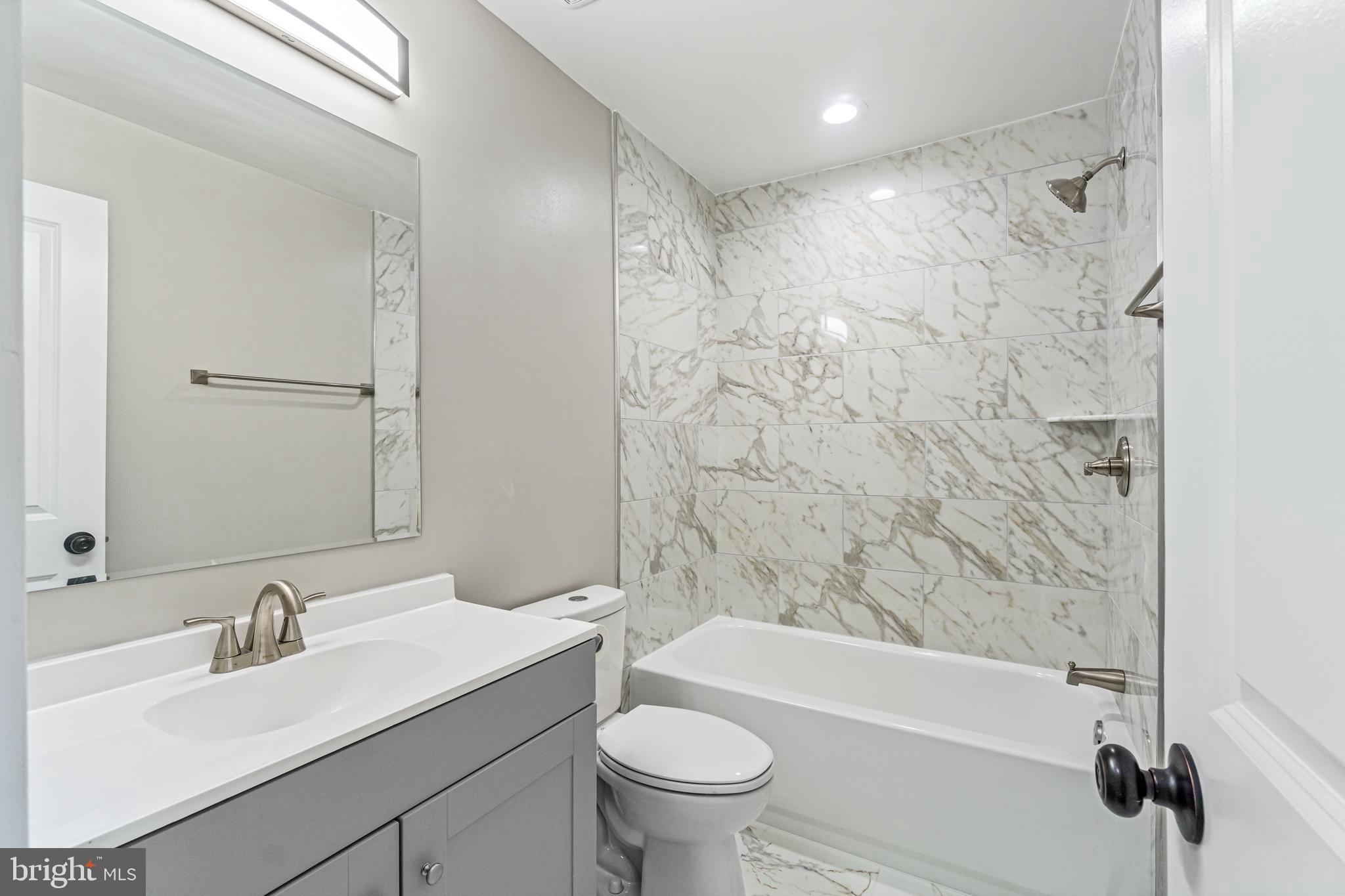 4534 Old Court Road Baltimore, MD 21208 - Photo 15 of 26 a bathroom with a granite countertop sink a toilet and a bathtub