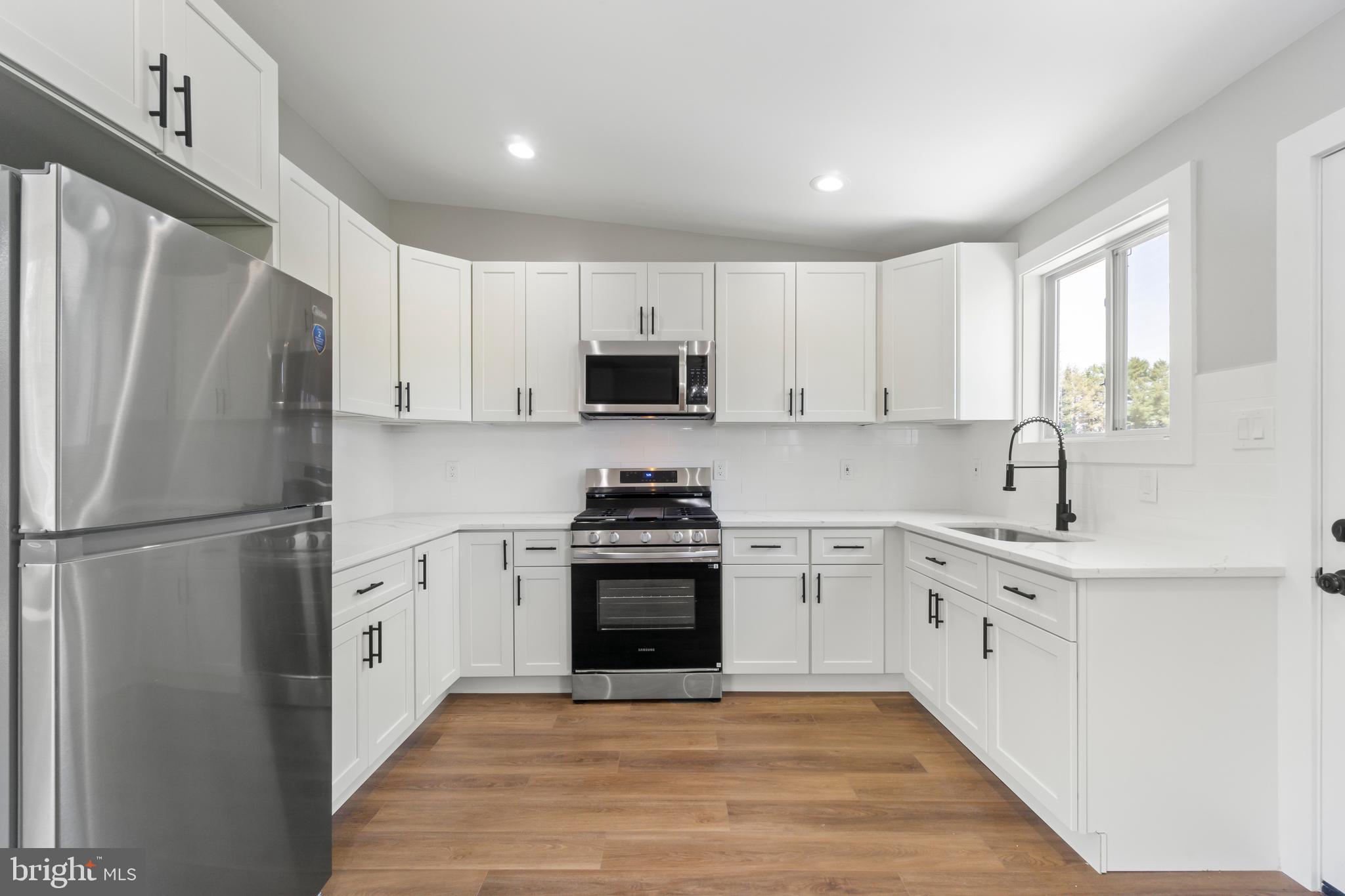 4534 Old Court Road Baltimore, MD 21208 - Photo 6 of 26 a kitchen with white cabinets and stainless steel appliances