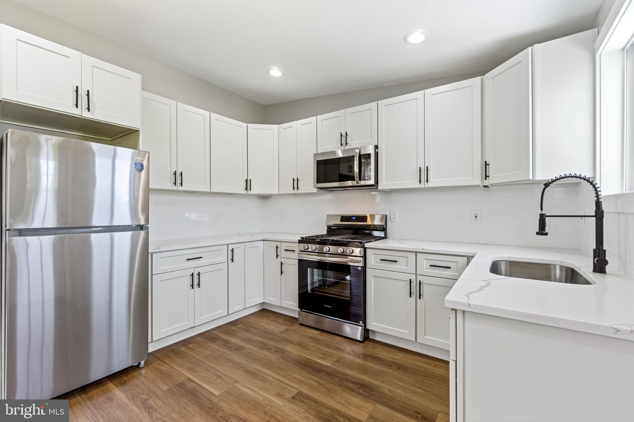 4534 Old Court Road Baltimore, MD 21208 - Photo 7 of 26 a kitchen with white cabinets sink and stainless steel appliances