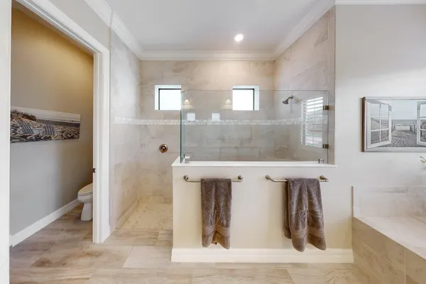 a bed sitting in a spacious bedroom next to a window