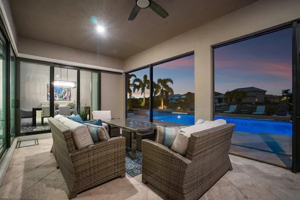 a view of swimming pool with outdoor seating and trees in the background