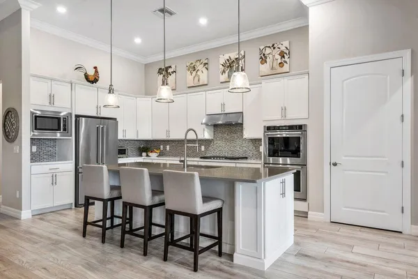 a large kitchen with a table and chairs