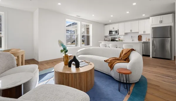 a living room with furniture and a wooden floor
