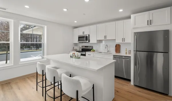 a kitchen with refrigerator cabinets and wooden floor