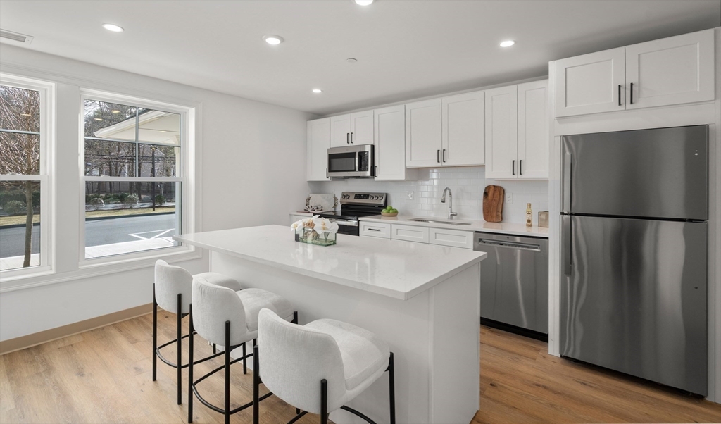 26 Union Street, Unit 102 Natick, MA 01760 - Photo 4 of 10 a kitchen with refrigerator cabinets and wooden floor