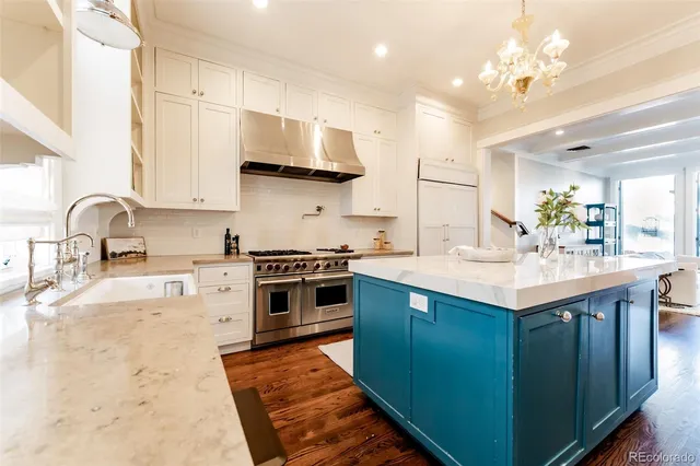 a kitchen with stainless steel appliances granite countertop a sink a stove and a refrigerator