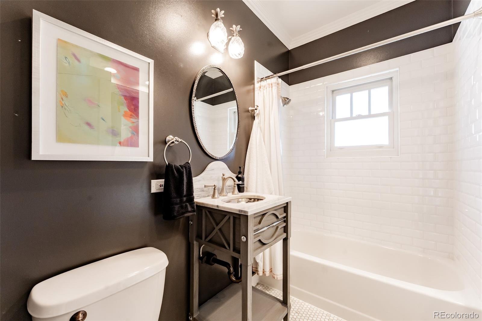 4535 Montview Boulevard Denver, CO 80207 - Photo 19 of 24 a bathroom with a sink a mirror a toilet and a bathtub