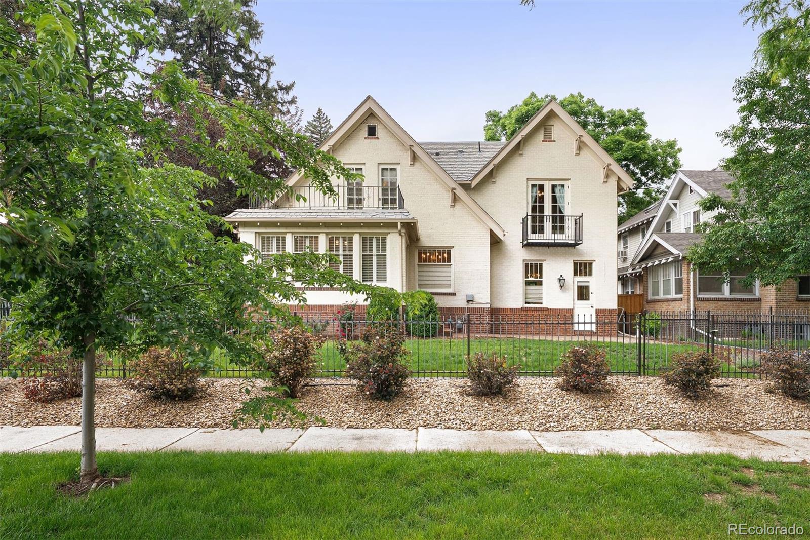 4535 Montview Boulevard Denver, CO 80207 - Photo 26 of 27 a view of a white house next to a yard with big trees