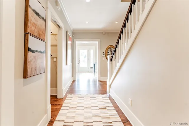 a view of a hallway with wooden floor and staircase