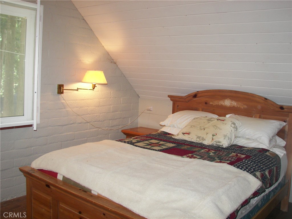 1101 Big Tree Lane Crestline, CA 92325 - Photo 19 of 30 a bedroom with a bed and painting on the wall