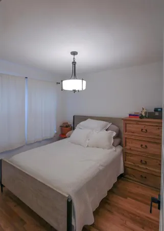 a bedroom with a bed and painting on the wall