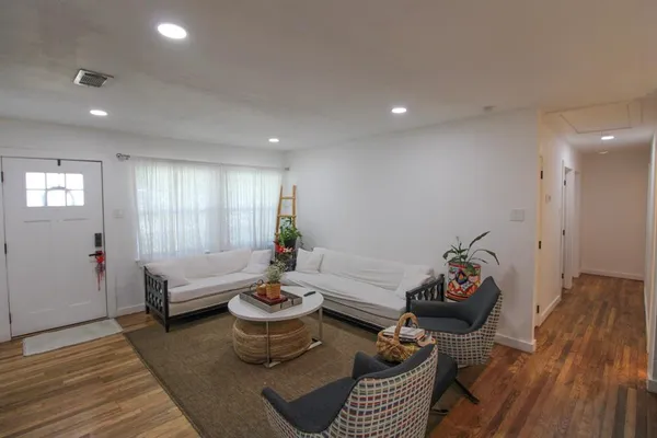 a living room with furniture and wooden floor