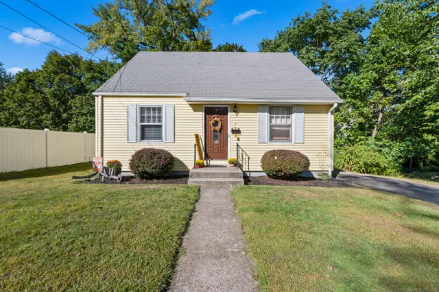 a view of a house with backyard and trees