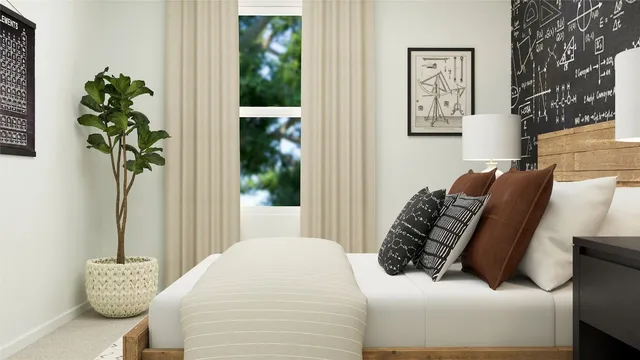 a bed sitting in a bedroom next to a window with potted plant