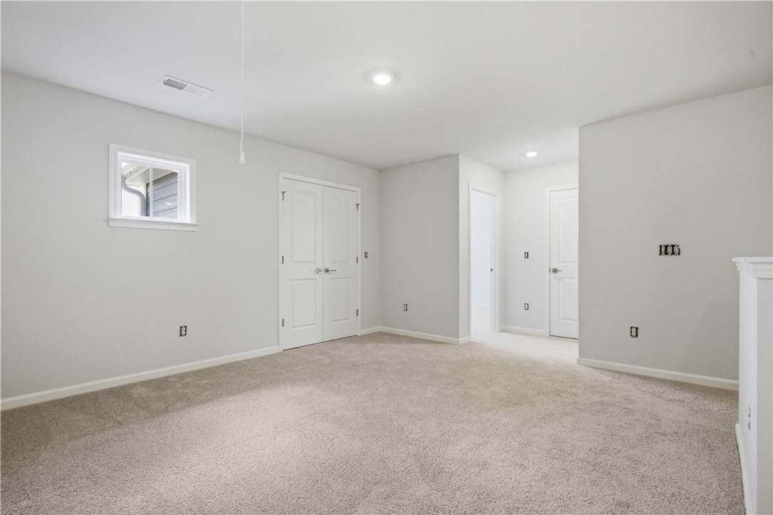 552 Hydrangea Street, Unit LOT 66 Seneca, SC 29678 - Photo 21 of 31 A spacious, naturally illuminated room featuring plush carpeting and pristine white walls.