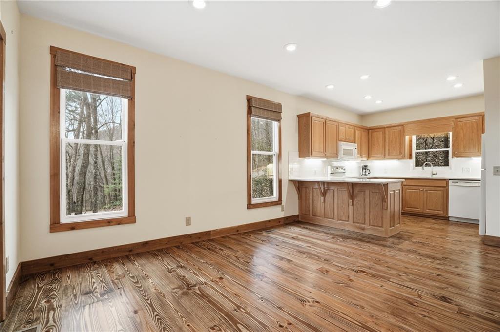 35 Red Oak Point Big Canoe, GA 30143 - Photo 16 of 62 a large white kitchen with kitchen island a sink wooden floor and a refrigerator