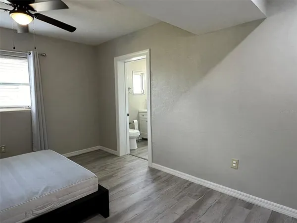 a bedroom with a bed and wooden floor