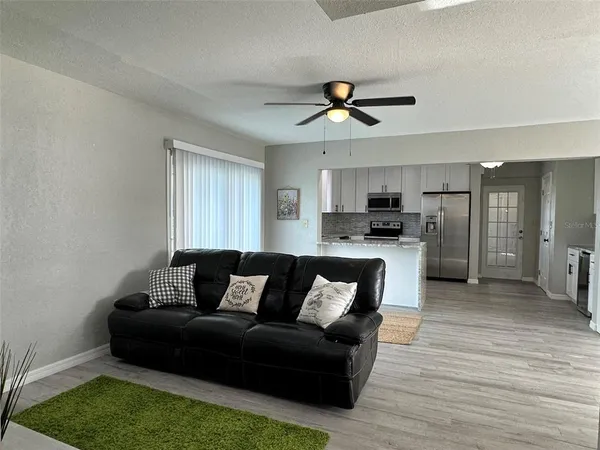 a living room with furniture and kitchen view