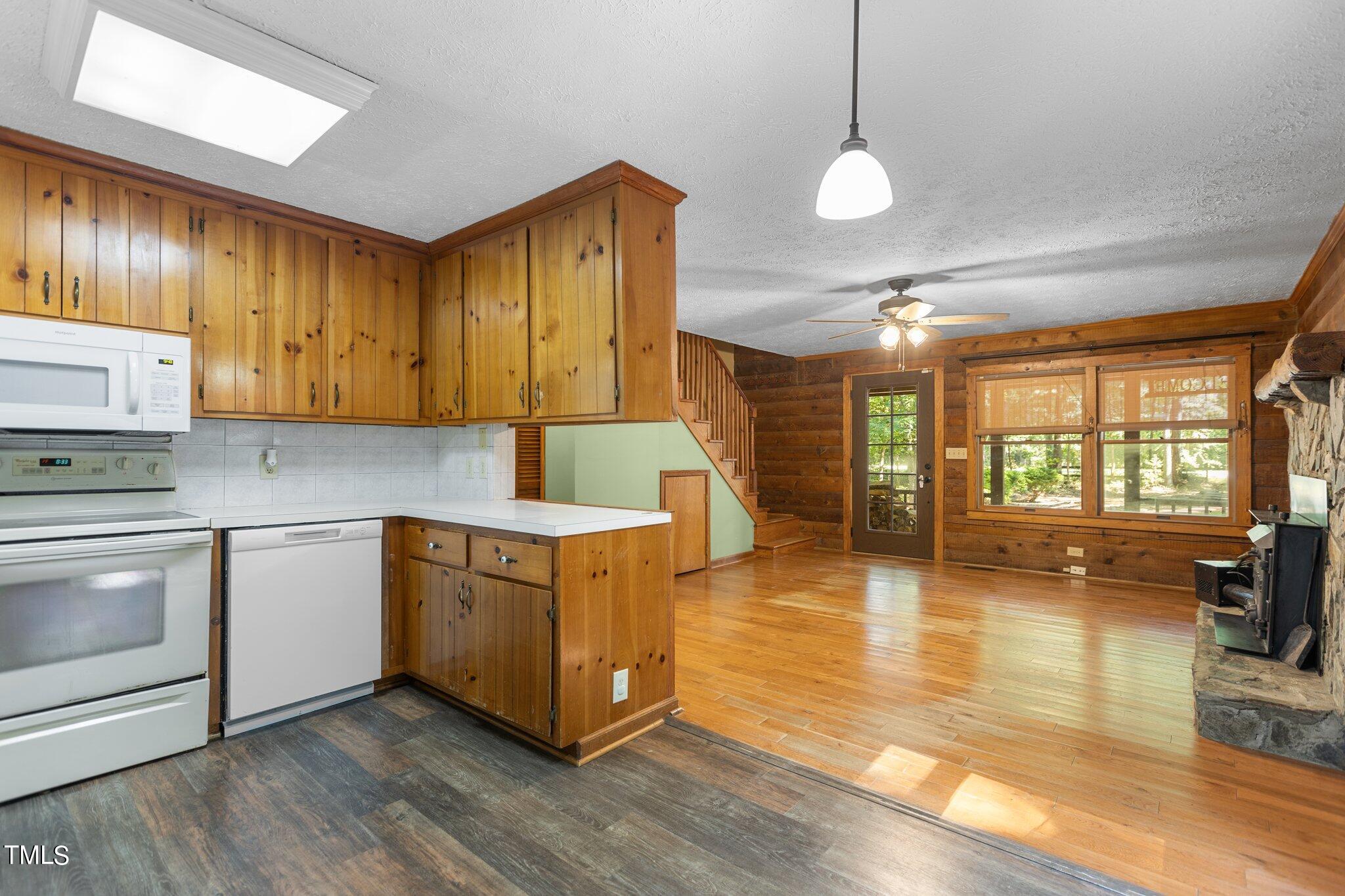 1819 Chambers Loop Road Timberlake, NC 27583 - Photo 7 of 41 a kitchen with wooden floors and white cabinets