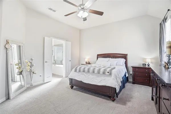 a spacious bedroom with a bed and a flat screen tv