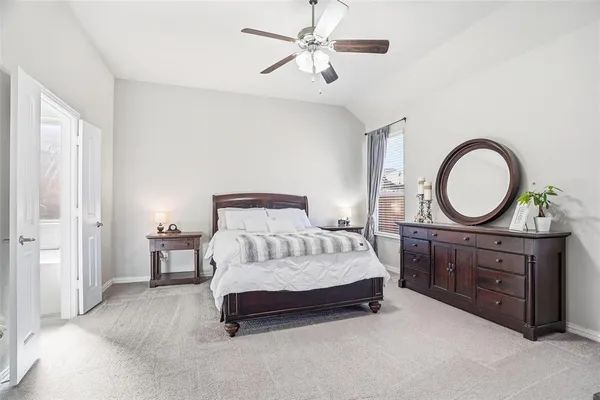 a bedroom with a large bed and a ceiling fan