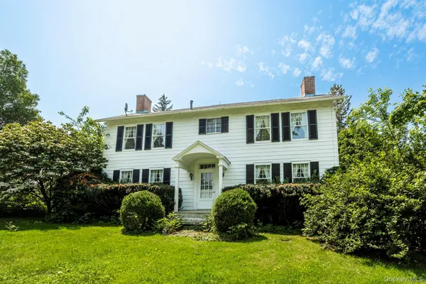 a front view of a house with a garden and yard