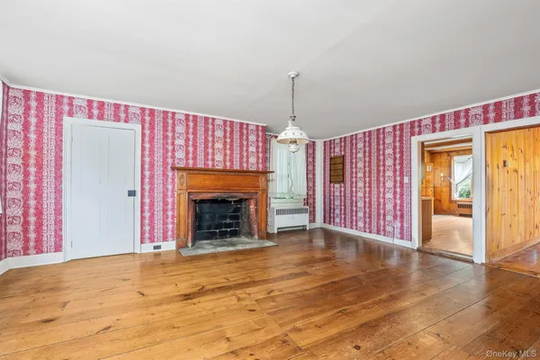 wooden floor fireplace and windows in an empty room