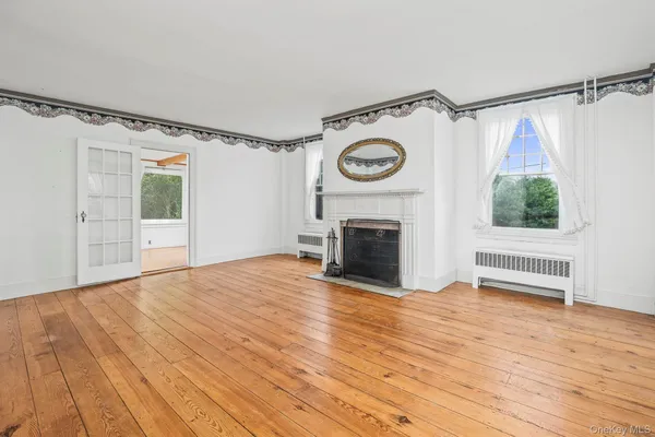 a view of empty room with wooden floor and fireplace