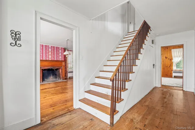 a view of a hallway with entryway wooden floor and front door