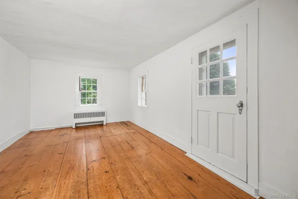 wooden floor in an empty room with a window