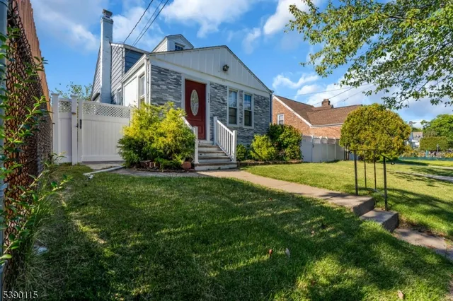 a front view of a house with a yard and trees