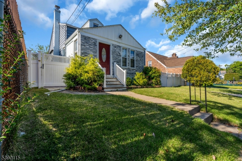 a front view of a house with a yard and trees