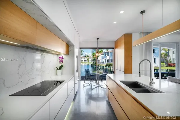 a kitchen that has a lot of cabinets a sink and a stove with wooden floor