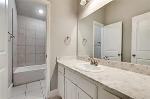 a bathroom with a granite countertop sink a mirror and a bathtub