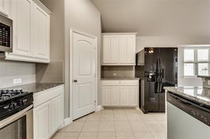 698 Harper Drive Fate, TX 75087 - Photo 4 of 18 a kitchen with a refrigerator stove and cabinets