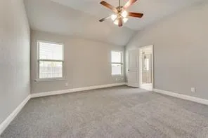 an empty room with chandelier fan and windows