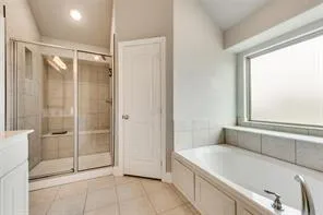 a spacious bathroom with a tub and shower