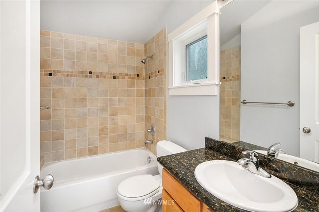 a bathroom with a granite countertop sink toilet bathtub and shower